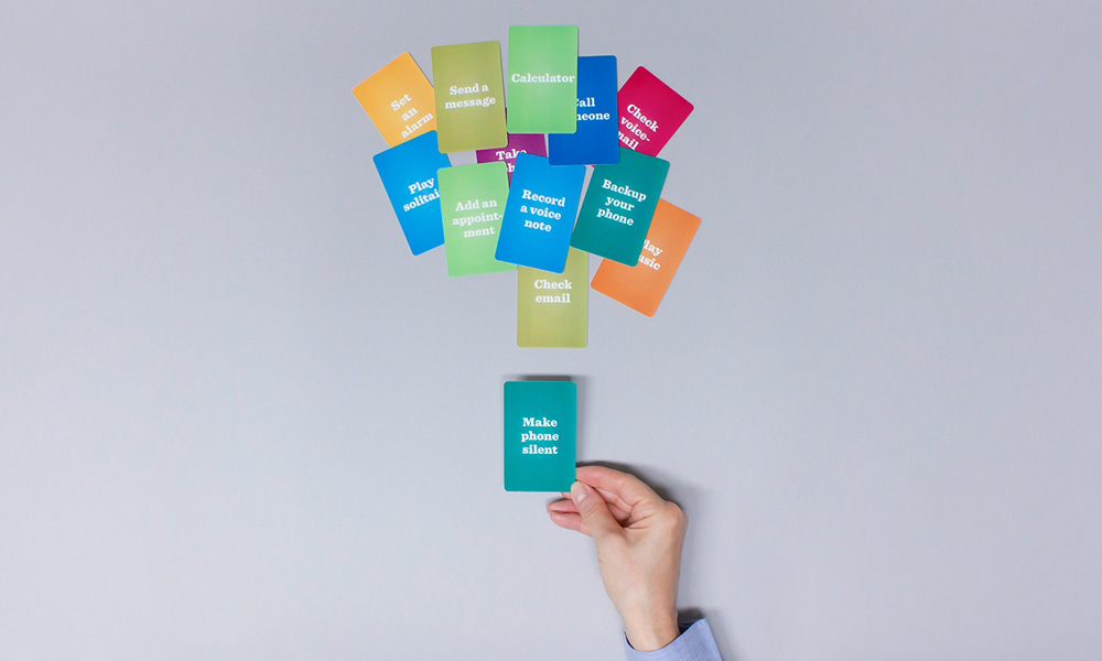 Top view of coloured cards labeled with phone actions and tasks